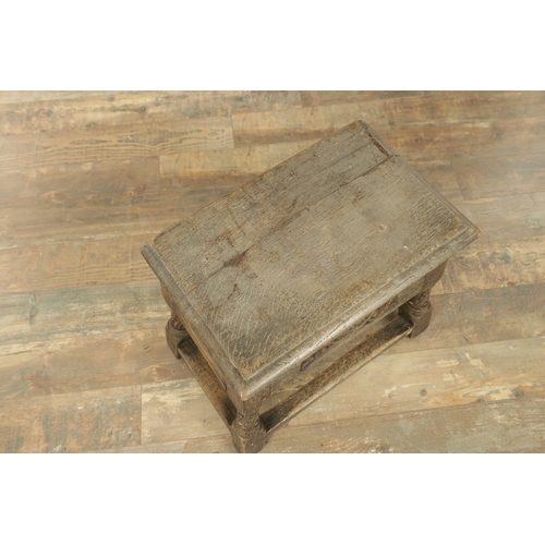 1323 - A 17TH CENTURY STYLE JOINED OAK BOX STOOL with a hinged top above a masked carved frieze raised on c... 