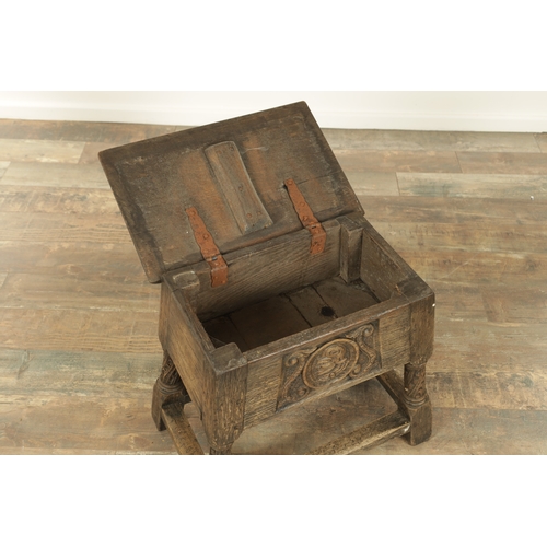 1323 - A 17TH CENTURY STYLE JOINED OAK BOX STOOL with a hinged top above a masked carved frieze raised on c... 