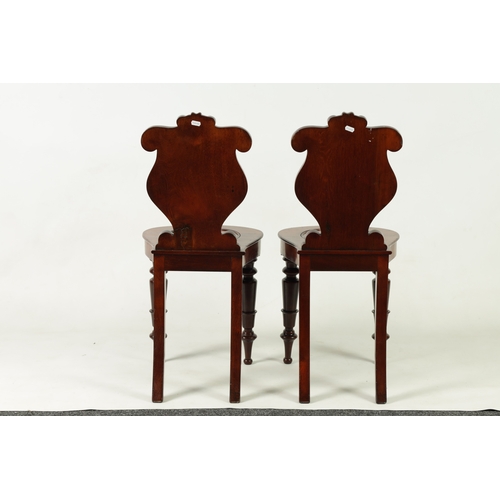 1346 - A PAIR OF WILLIAM IV MAHOGANY HALL CHAIRS with leaf-carved shaped backs above rounded seats; raised ... 