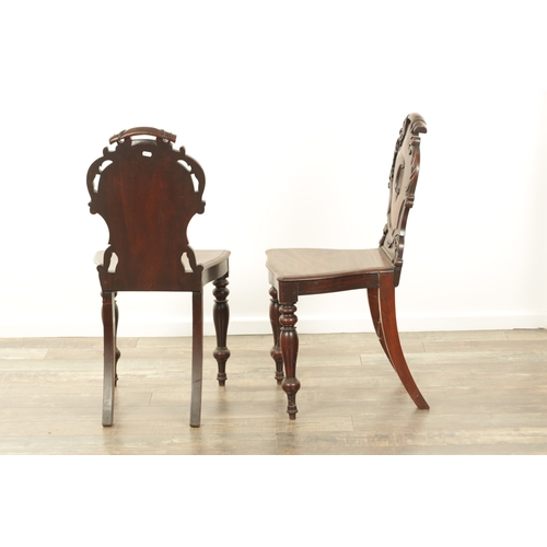 1368 - A PAIR OF 19TH CENTURY MAHOGANY HALL CHAIRS with leaf-carved shaped backs and raised on ring turned ... 