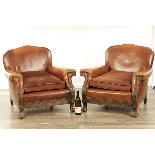 1376 - A PAIR OF EDWARDIAN OAK AND TAN LEATHER UPHOLSTERED ARMCHAIRS with loose cushion seats and carved oa... 