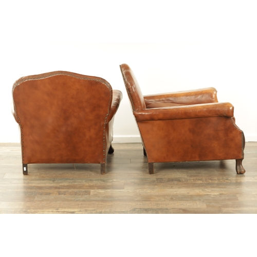 1376 - A PAIR OF EDWARDIAN OAK AND TAN LEATHER UPHOLSTERED ARMCHAIRS with loose cushion seats and carved oa... 