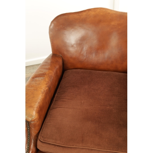 1376 - A PAIR OF EDWARDIAN OAK AND TAN LEATHER UPHOLSTERED ARMCHAIRS with loose cushion seats and carved oa... 