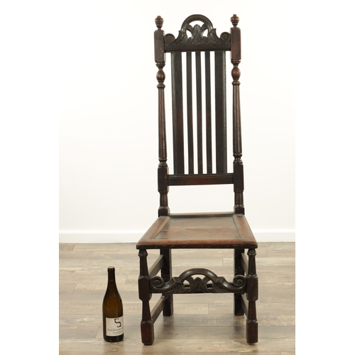 1383 - A CHARLES II OAK HALL CHAIR with a raised slatted back and panelled seat above turned legs and carve... 