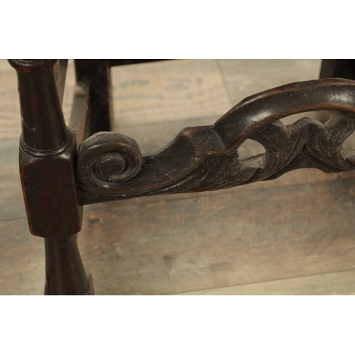 1383 - A CHARLES II OAK HALL CHAIR with a raised slatted back and panelled seat above turned legs and carve... 