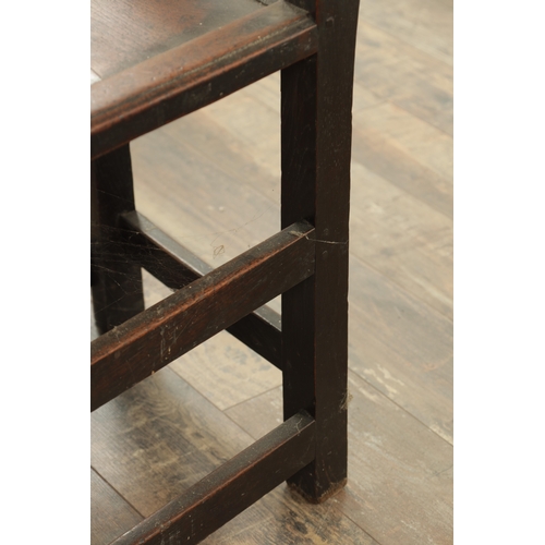 1383 - A CHARLES II OAK HALL CHAIR with a raised slatted back and panelled seat above turned legs and carve... 