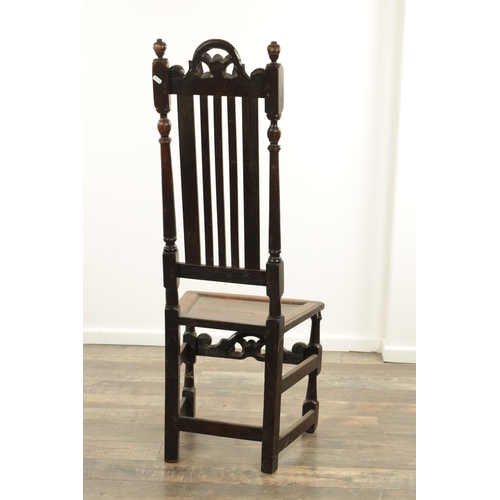 1383 - A CHARLES II OAK HALL CHAIR with a raised slatted back and panelled seat above turned legs and carve... 