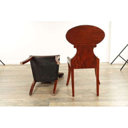 1389 - A PAIR OF REGENCY STYLE MAHOGANY HALL CHAIRS with dished seats and sabre leaf carved leg supports. (... 