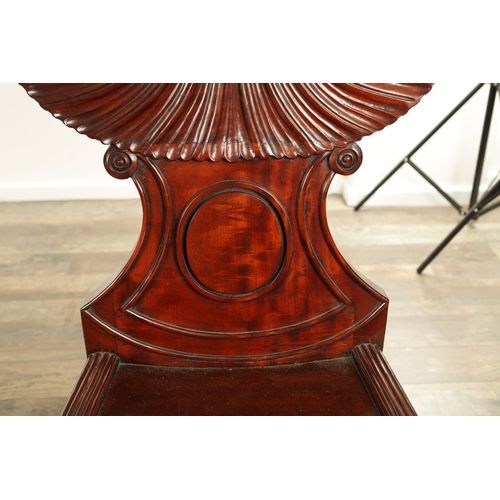 1389 - A PAIR OF REGENCY STYLE MAHOGANY HALL CHAIRS with dished seats and sabre leaf carved leg supports. (... 