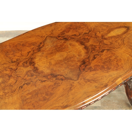 1416 - A VICTORIAN BURR WALNUT SERPENTINE SHAPED LIBRARY TABLE with moulded edge top above leaf carved end ... 