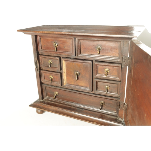 1417 - A WILLIAM AND MARY GEOMETRIC INLAID WALNUT SPICE CABINET with hinged door revealing a bank of small ... 