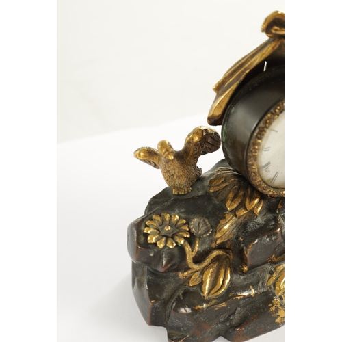 970 - A REGENCY ENGLISH BRONZE AND GILT BRONZE SMALL MANTEL CLOCK modelled with a cherub laying in a natur... 