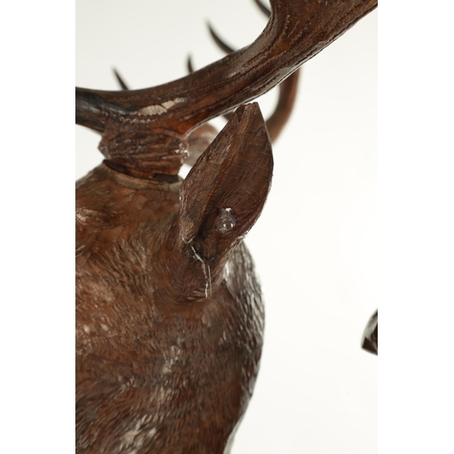 975 - A LARGE 19TH CENTURY CARVED LINDEN WOOD BLACK FOREST MANTEL CLOCK modelled as a stag amongst foliage... 