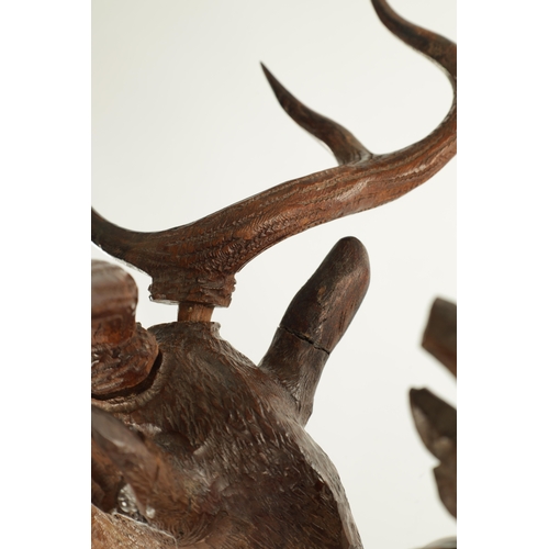 975 - A LARGE 19TH CENTURY CARVED LINDEN WOOD BLACK FOREST MANTEL CLOCK modelled as a stag amongst foliage... 