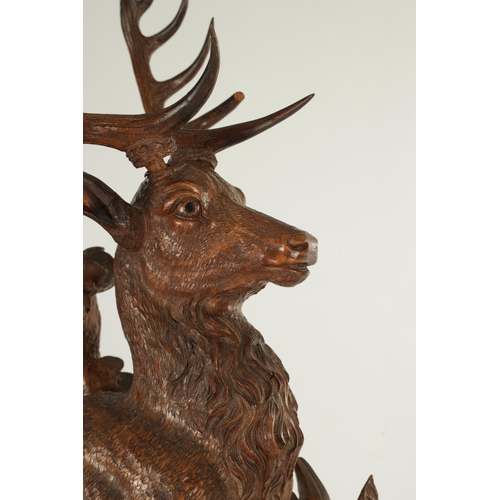 975 - A LARGE 19TH CENTURY CARVED LINDEN WOOD BLACK FOREST MANTEL CLOCK modelled as a stag amongst foliage... 