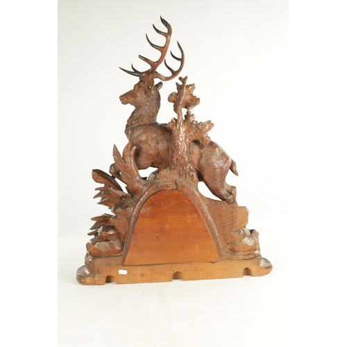 975 - A LARGE 19TH CENTURY CARVED LINDEN WOOD BLACK FOREST MANTEL CLOCK modelled as a stag amongst foliage... 