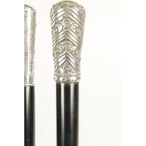 518 - TWO EARLY 20TH CENTURY GENTLEMANS EVENING CANES with silver tops and ebonised shafts - one hallmarke... 