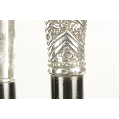 518 - TWO EARLY 20TH CENTURY GENTLEMANS EVENING CANES with silver tops and ebonised shafts - one hallmarke... 