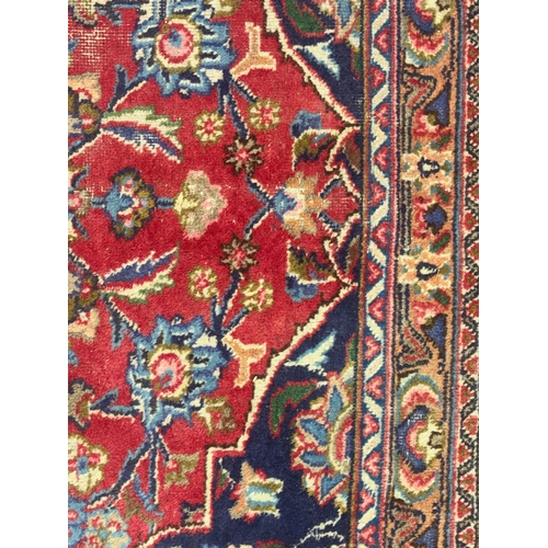 A LARGE ANTIQUE PERISIAN RUG brightly coloured with geometric panels ...