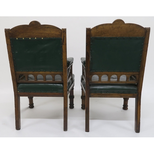 1 - A pair of Victorian oak Gothic armchairs with green leather upholstery marked with the Kendal coat o... 