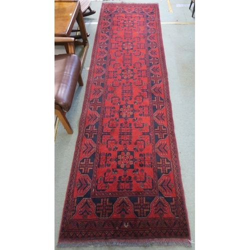 59 - A red ground eastern style runner 294cm long x 83cm wide