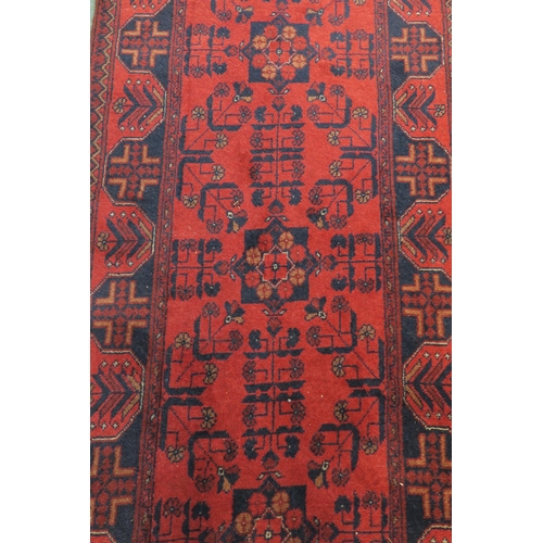 59 - A red ground eastern style runner 294cm long x 83cm wide