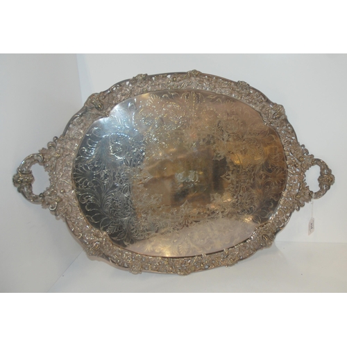 814 - A silver plated twin handles serving tray, oval with pierced rim with fruit and vine embossed decora... 