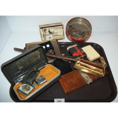 386 - A tray lot including bosun whistle, cigarette cards, keys, lighters etc