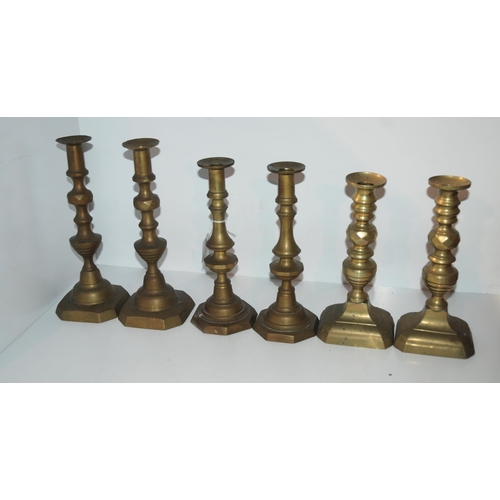 409 - A brass jelly pan and three pairs of brass candlesticks