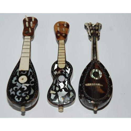 427 - Three tortoiseshell and mother of pearl inlaid miniature instruments, two mandolins and guitar, 11cm... 