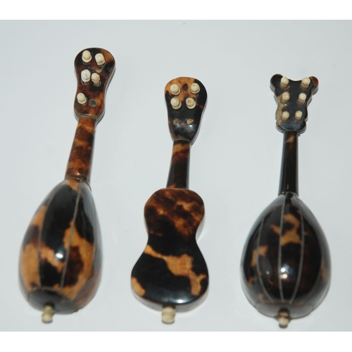 427 - Three tortoiseshell and mother of pearl inlaid miniature instruments, two mandolins and guitar, 11cm... 