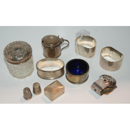 738 - Three silver napkin rings, a pill box, a salt, a mustard, a silver-topped jar and white-metal thimbl... 