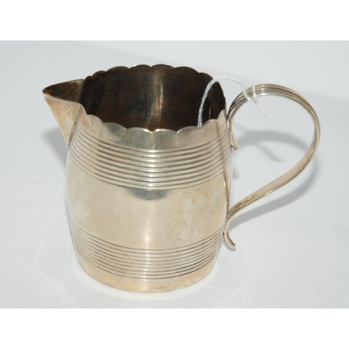 775 - A silver cream jug, London 1792, the banded body with frilled rim and scrolling handle, 6.8cm high, ... 