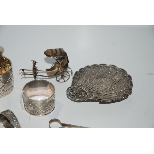 784 - A mixed lot of white-metal items filigree dish, bottle pourer, rickshaw, two napkin rings, spoon and... 