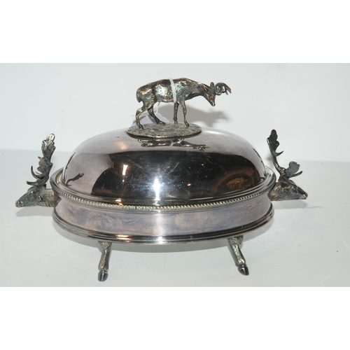 791 - A silver-plated butter dish, the domed cover with stag finial and stag head handles on hoof feet wit... 