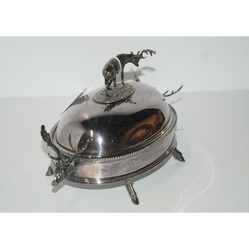 791 - A silver-plated butter dish, the domed cover with stag finial and stag head handles on hoof feet wit... 