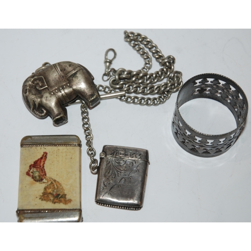 822 - A lot comprising a silver vesta on white metal albert, another vesta, a napkin ring and a white meta... 