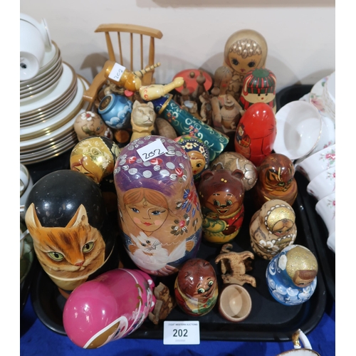 202 - A lot comprising a selection of painted Matryoshkas/Russian nesting dolls, pokerwork novelty figures... 