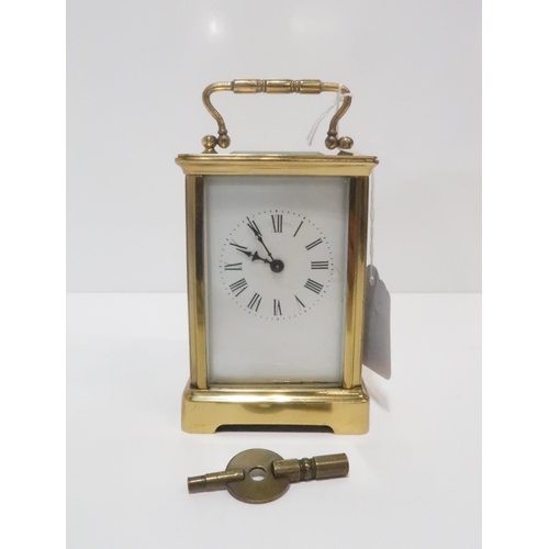 221 - A brass carriage clock with white enamel dial and roman numeral chapter ring