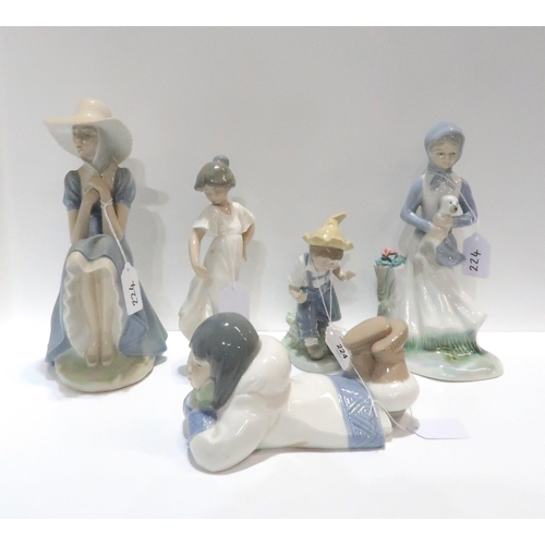 224 - A Nao figure of a lady in a hat, a girl lying down, a girl in a white dress, a boy, and another figu... 