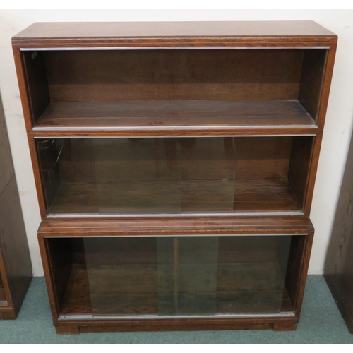 100 - A 20th century oak three tier stacking bookcase with glass sliding doors, 112cm high x 89cm wide x 2... 