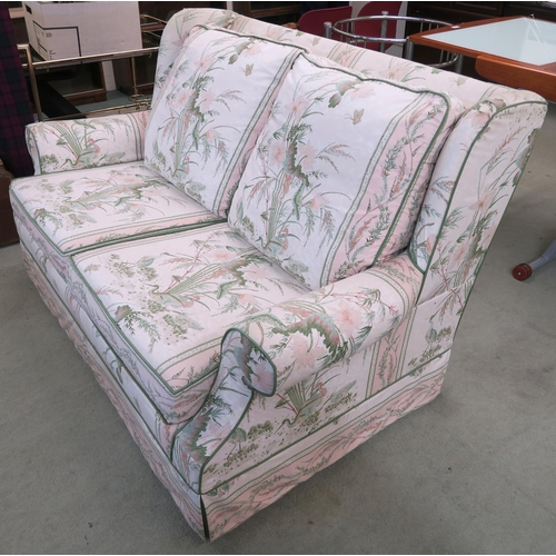 110 - A 20th century floral upholstered wing back two seater settee, 88cm high x 143cm wide x 98cm deep