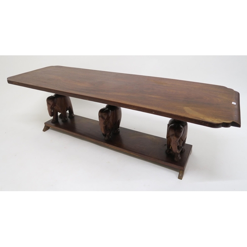 126 - A 20th century hardwood coffee table with carved elephant supports, oval occasional table with carve... 