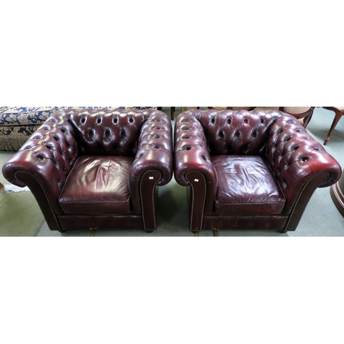 56 - A pair of contemporary oxblood leather upholstered chesterfield club chairs, 70cm high x 102cm wide ... 