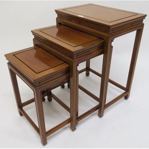 80 - A contemporary hardwood oriental style nest of three tables, 67cm high x 49cm wide x 35cm deep