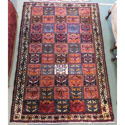 83 - A multicoloured Bakhtiari rug with panel design and white borders, 219cm x 149cm