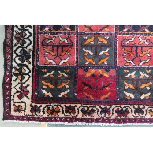 83 - A multicoloured Bakhtiari rug with panel design and white borders, 219cm x 149cm