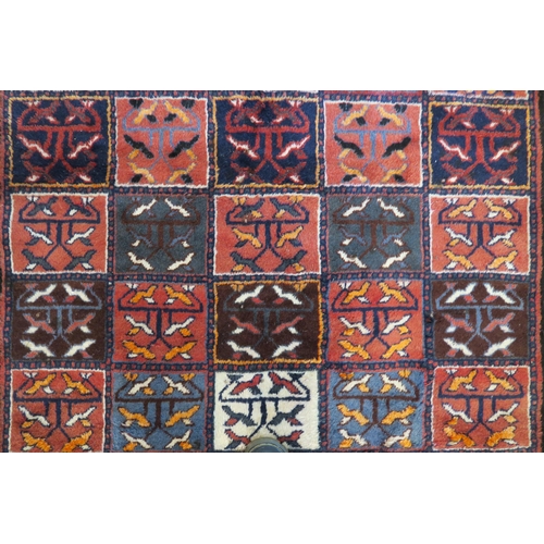 83 - A multicoloured Bakhtiari rug with panel design and white borders, 219cm x 149cm