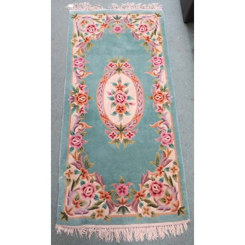 85 - A green ground rug with floral central medallion and border, 190cm long x 90cm wide