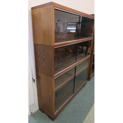 98 - A 20th century oak three tier stacking bookcase with glass sliding doors, 108cm high x 89cm wide x 2... 